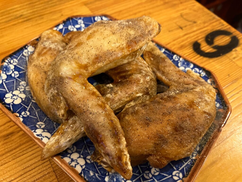 手羽揚げ胡椒が4本盛られた皿